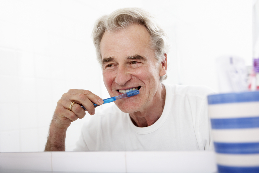 old man brushing teeth